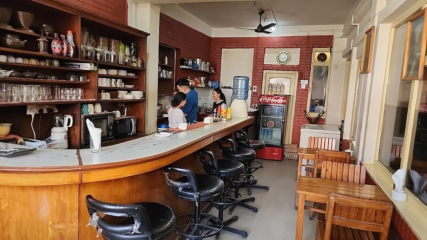 Inside Chikusa: the wooden counter, bar stools and shelves of cups where every coffee is hand-brewed